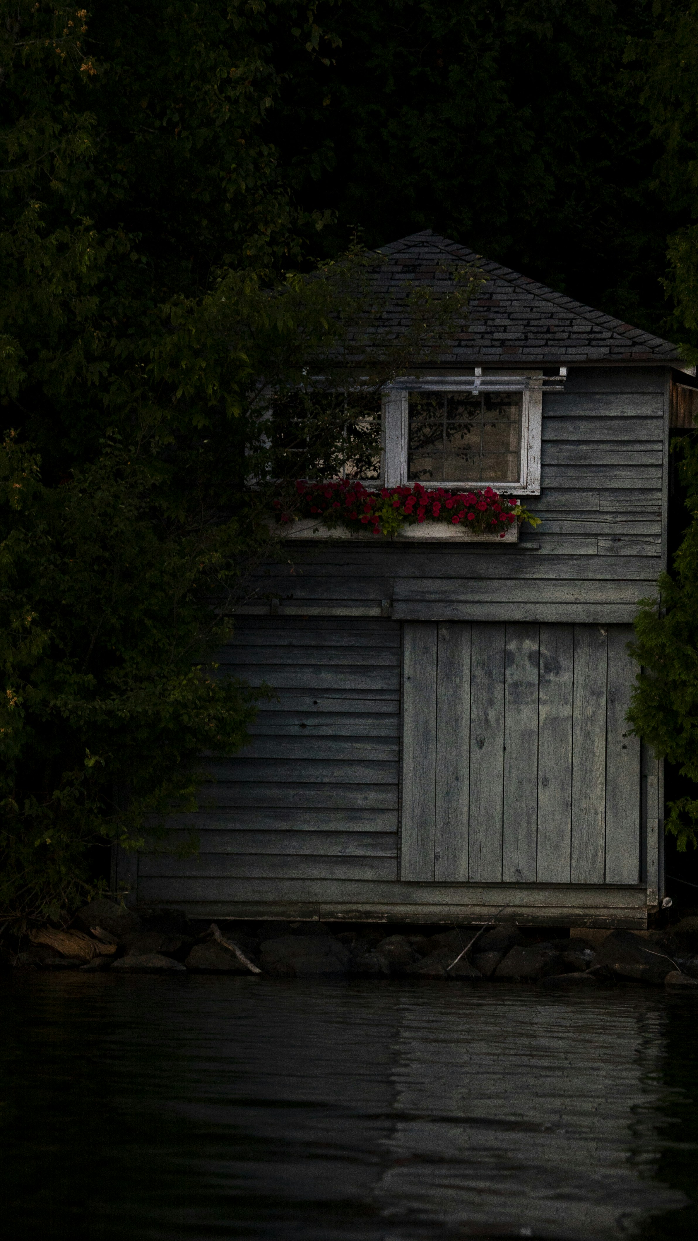 una rimessa per barche con una finestra e una fioriera sul tetto