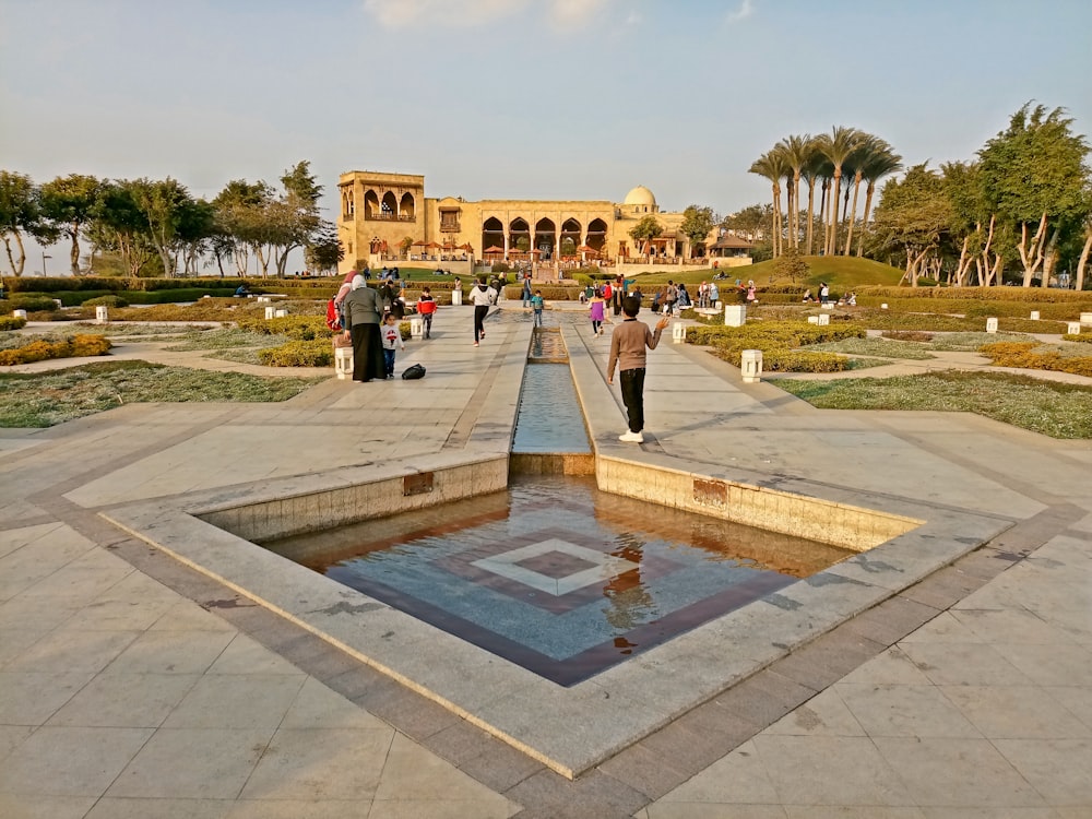 a group of people standing around a fountain