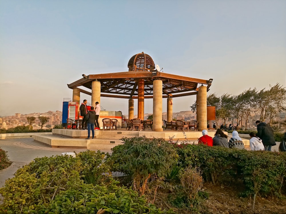 a group of people standing around a gazebo