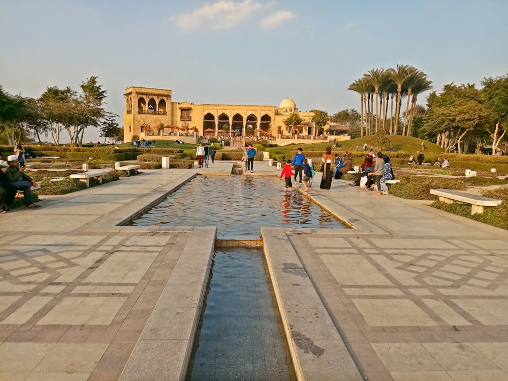 a group of people standing around a water fountain