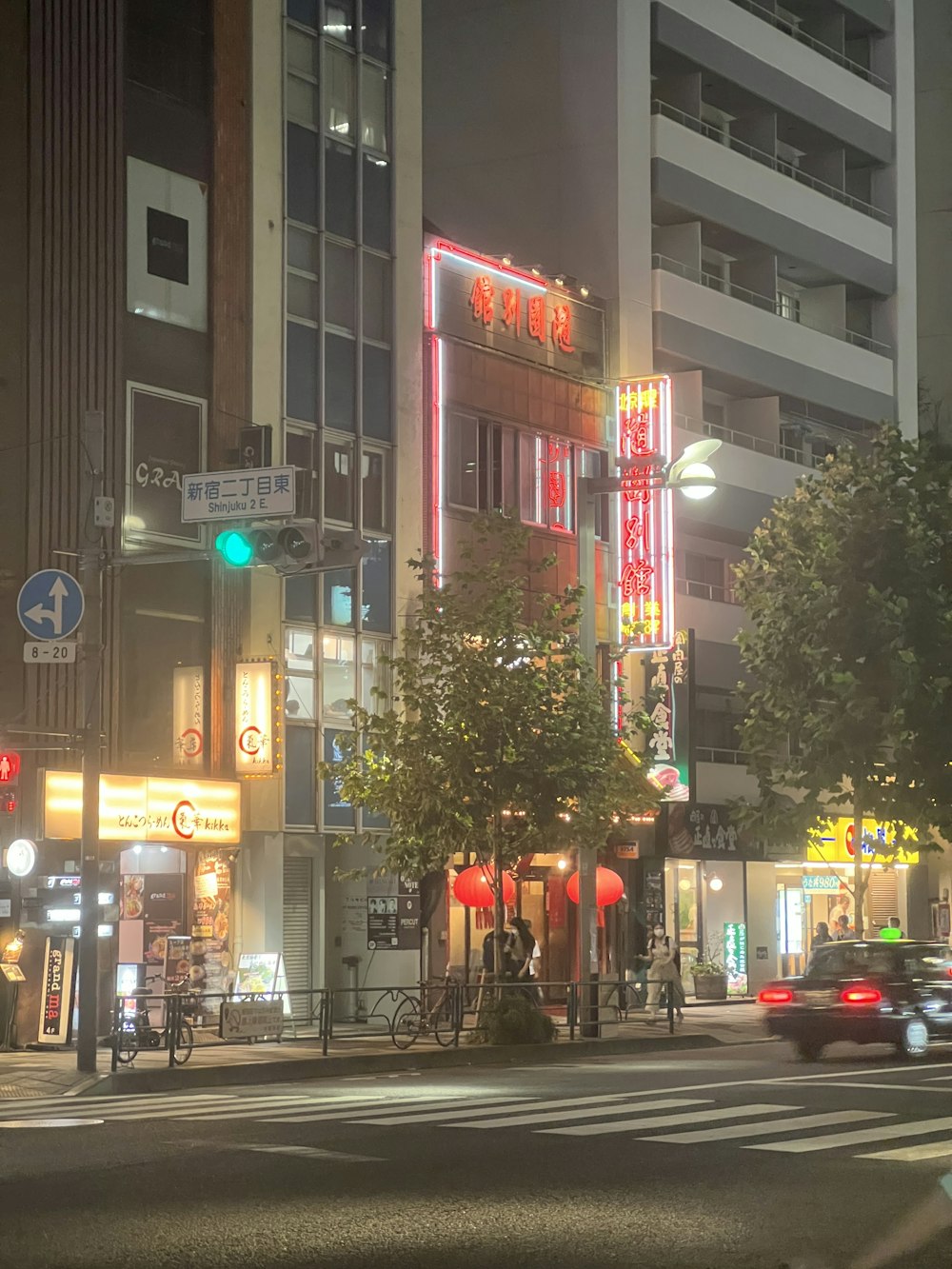 a city street at night with cars and people