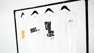 Modern black and white casual t-shirts neatly folded on a minimalist wooden table.