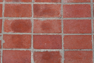 Red rectangular bricks arranged in a grid pattern with visible gray mortar lines in between.