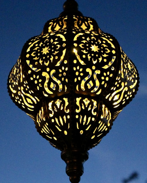 A beautifully crafted lamp inspired by world religions, glowing warmly in a cozy room.