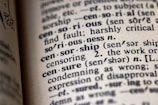 An open dictionary focusing on the word 'censorship' with related terms and pronunciations nearby. The print is clear, emphasizing the definitions and their phonetic transcriptions.