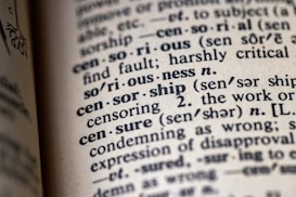 An open dictionary focusing on the word 'censorship' with related terms and pronunciations nearby. The print is clear, emphasizing the definitions and their phonetic transcriptions.