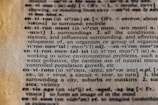Close-up view of a dictionary page featuring the entry for the word 'environment,' including its pronunciation, definition, and related terms such as 'environmentalist.' The text explains the concept in detail and mentions issues like water pollution and resource use.