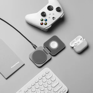 Assorted tech accessories including earbuds and chargers arranged neatly on light gray fabric