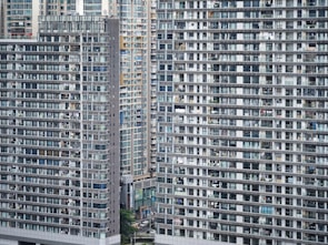 A dense cluster of modern high-rise apartment buildings with numerous windows and balconies, showcasing an urban residential area.