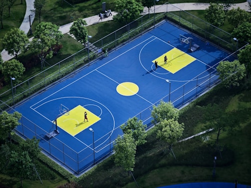 A vibrant basketball court with players in blue and orange jerseys during a lively match