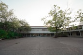 An inspiring landscape view of a school building surrounded by greenery, representing a safe learning environment.