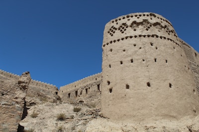 a tall stone tower sitting on top of a rocky hillside