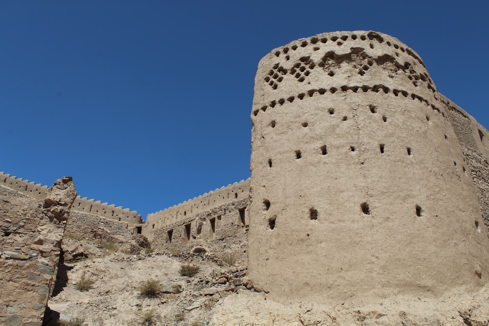 un'alta torre di pietra seduta sulla cima di una collina rocciosa