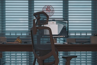 a computer desk with a monitor and a chair