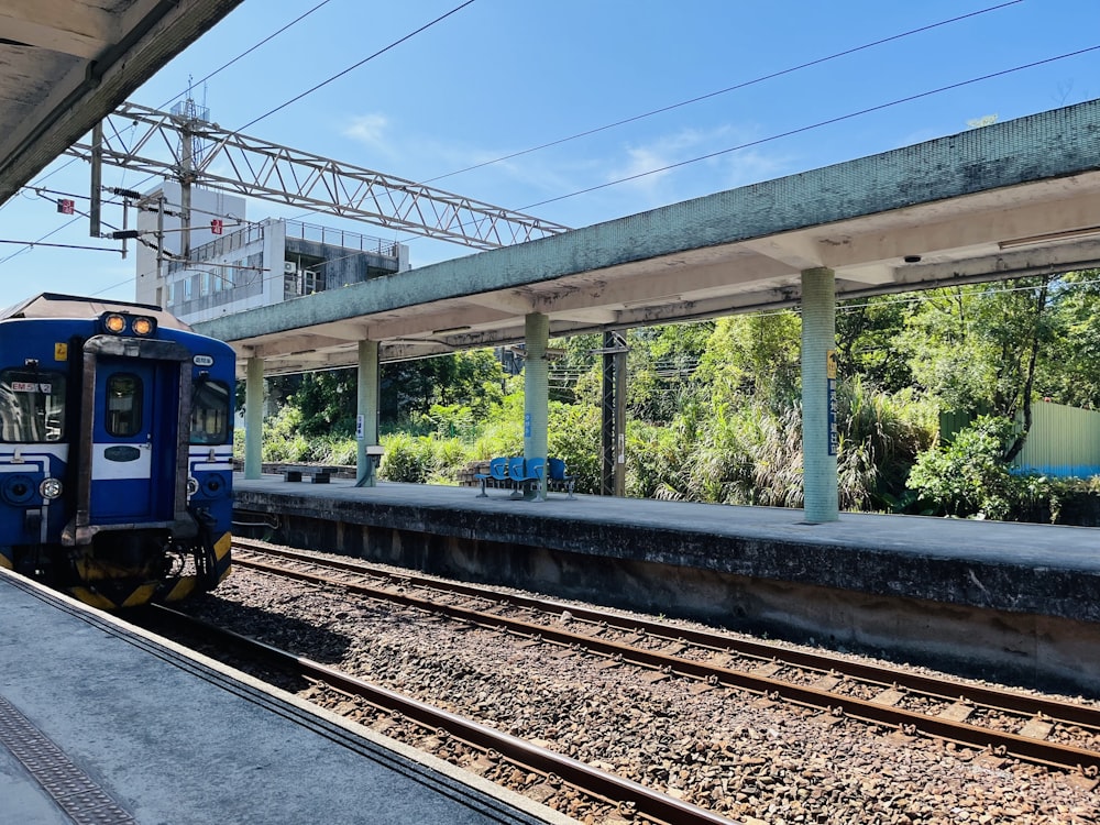 a blue train pulling into a train station