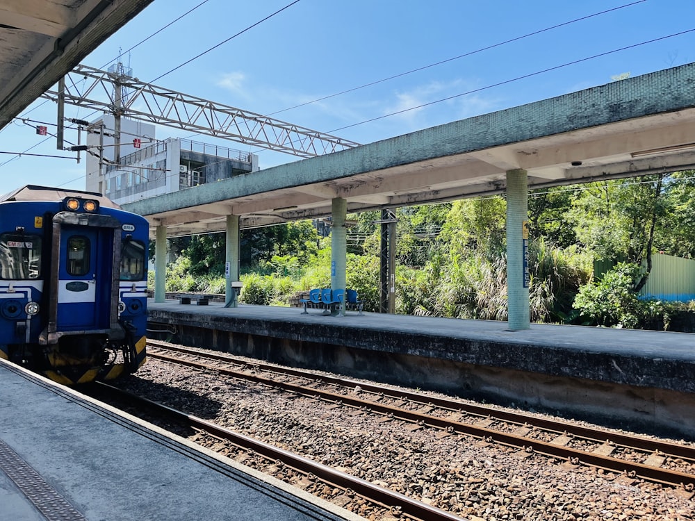 Un tren azul entrando en una estación de tren