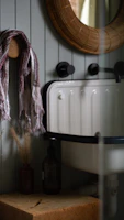 A cozy bathroom corner featuring a lustranest bathroom vanity stool beside a decorative mirror.