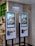 Two digital kiosks for placing takeout orders, displaying images of food items. They are located in a restaurant setting with visible payment interfaces and a sign above indicating 'Takeout Order' in both English and Chinese.