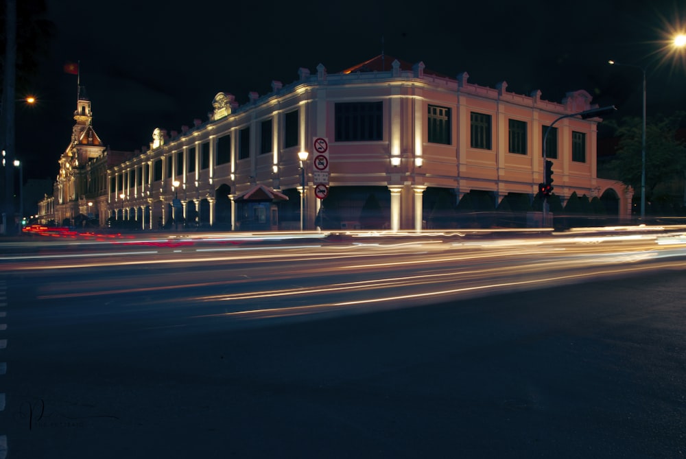 a city street at night with a building lit up