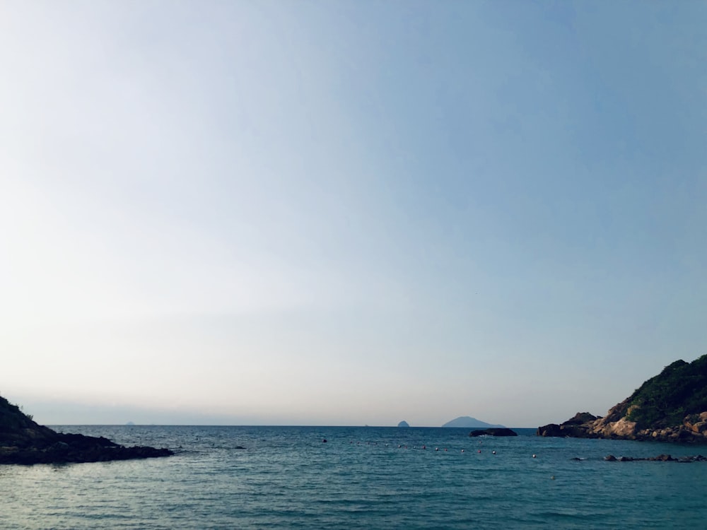 a body of water with a hill in the background