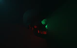 Close-up of a skull icon illuminated by red neon light on a dark background.