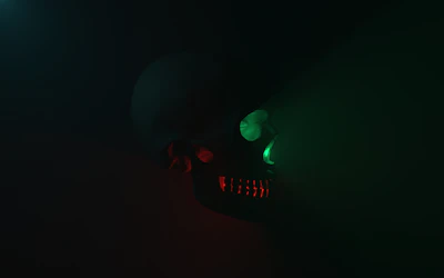 Close-up of a skull icon illuminated by red neon light on a dark background.
