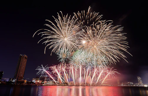 A vibrant grand opening fireworks display lighting up a city skyline at night.