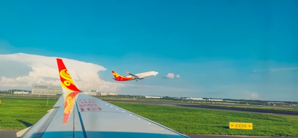 A vibrant airplane taking off against a clear blue sky at sunrise.