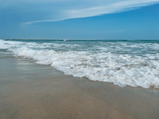 A calm beach scene with gentle waves and soft sand