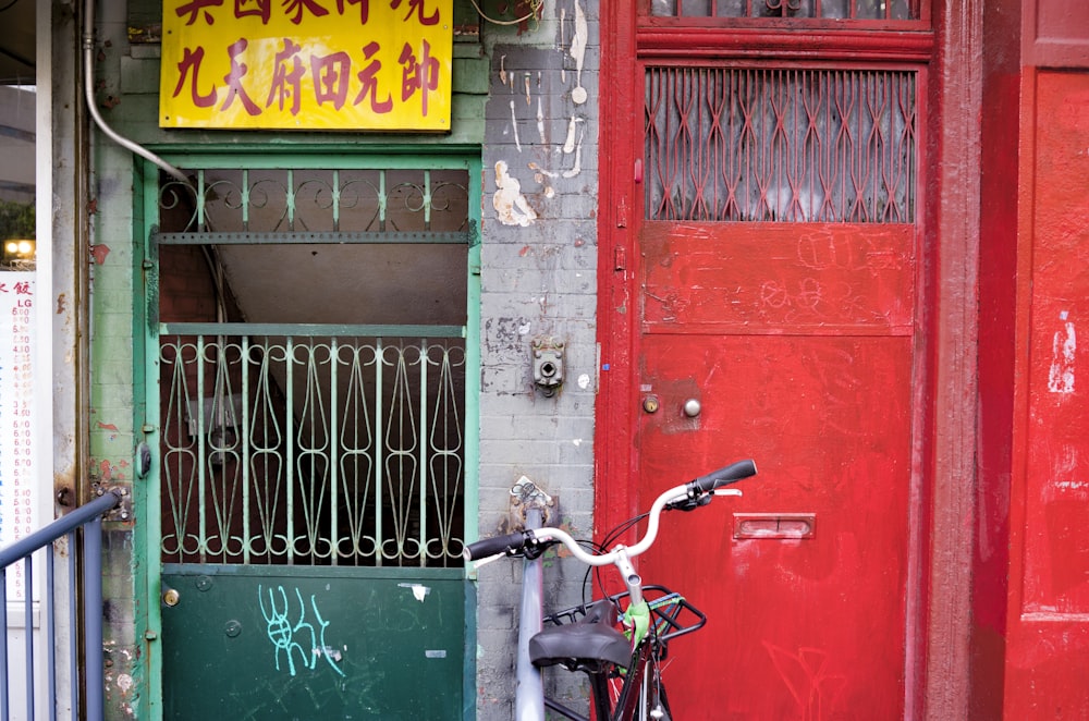 a bicycle parked in front of a red door