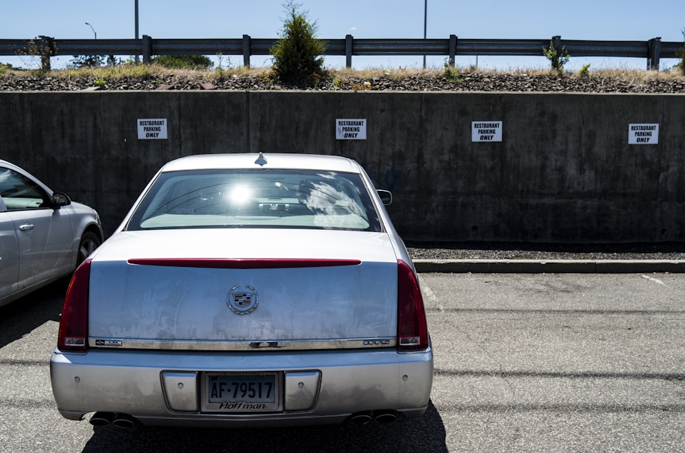 a white car parked in a parking lot next to another car