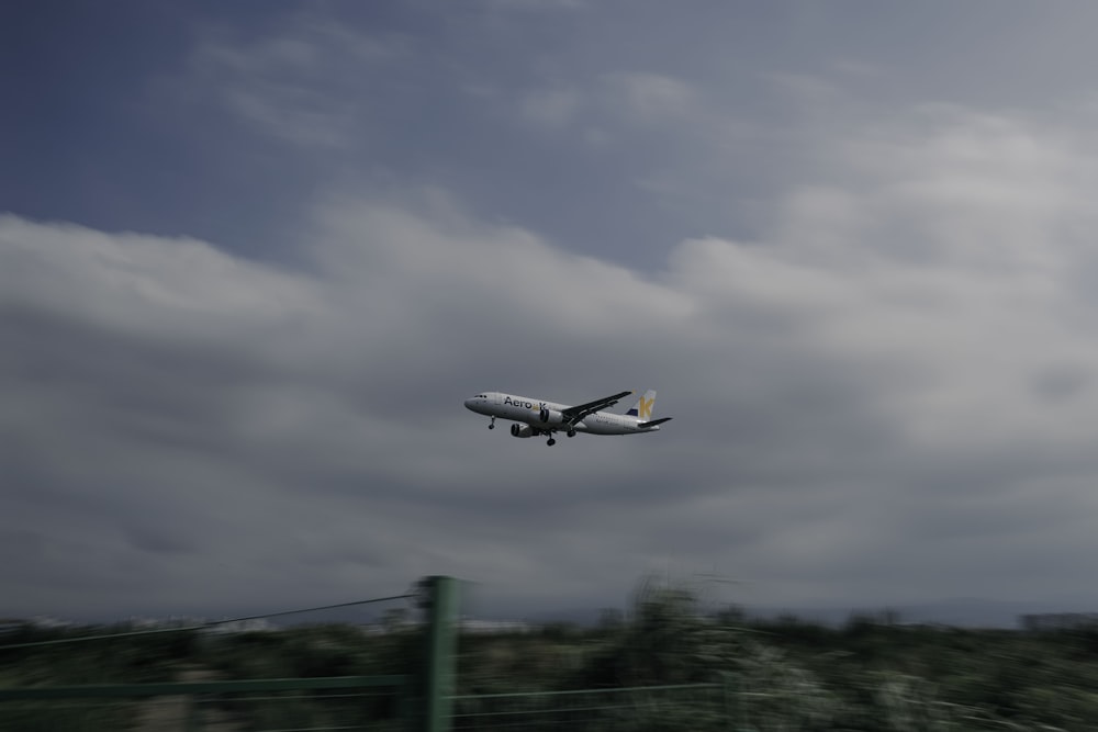 an airplane is flying in the sky over a field