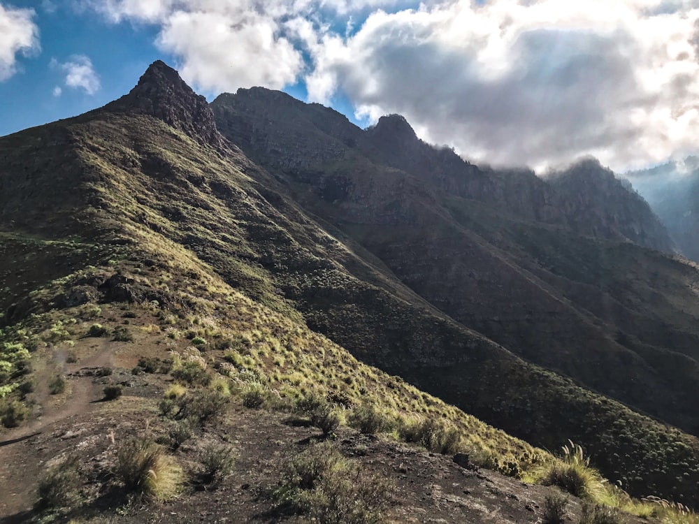 a view of the top of a mountain with clouds in the sky