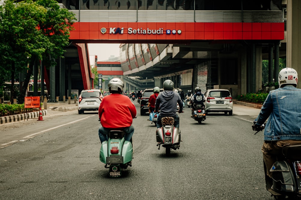 a group of people riding motorcycles down a street