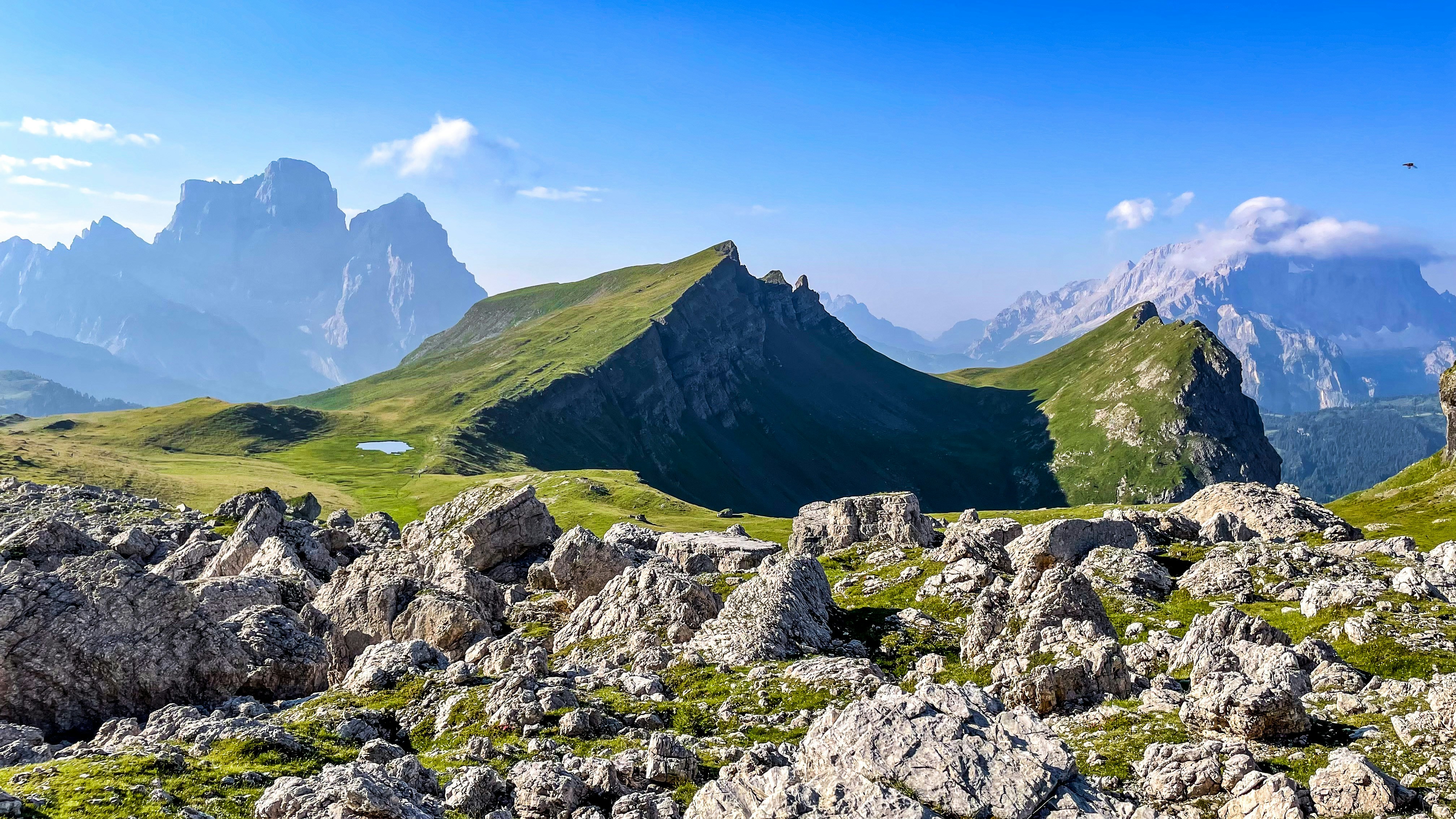 a mountain range with rocks and grass in the foreground