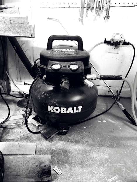Photo of a technician servicing an air compressor in a modern workshop.