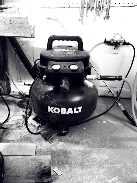 Photo of a technician servicing an air compressor in a modern workshop.