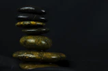 Soft green and white stones arranged thoughtfully on a wooden table symbolizing balance and intuition.