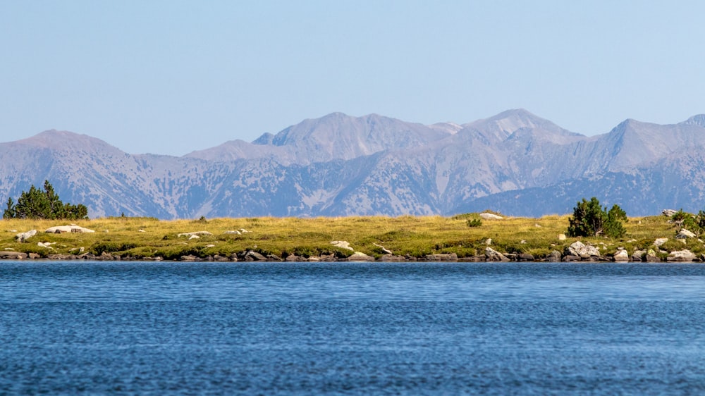 a body of water with mountains in the background