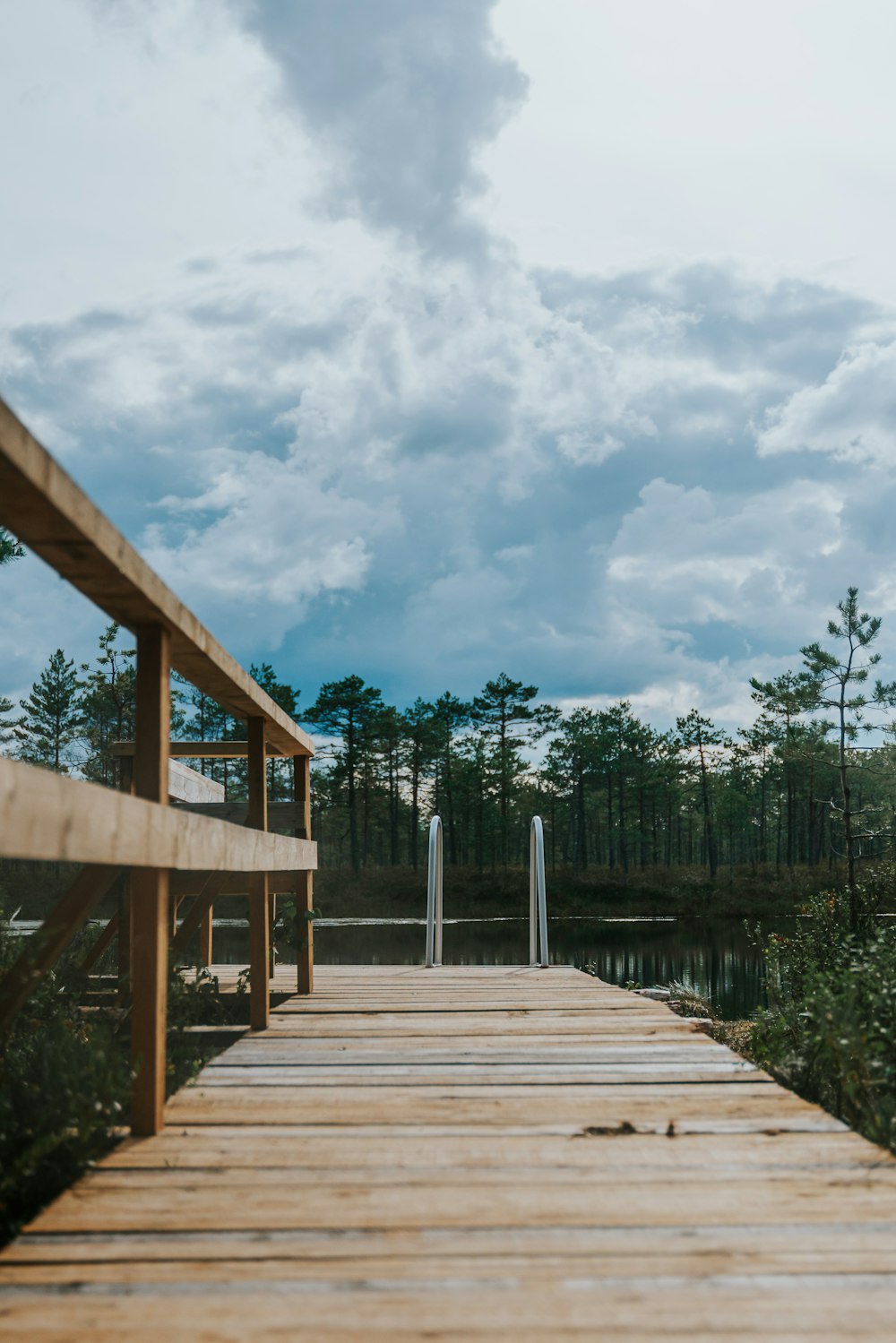 a wooden dock with a cloudy sky in the background