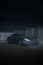 A sleek car being painted in a modern garage.