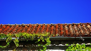 Wide shot of a Surabaya home finished with rich red-brown clay tiles and matching ridge caps