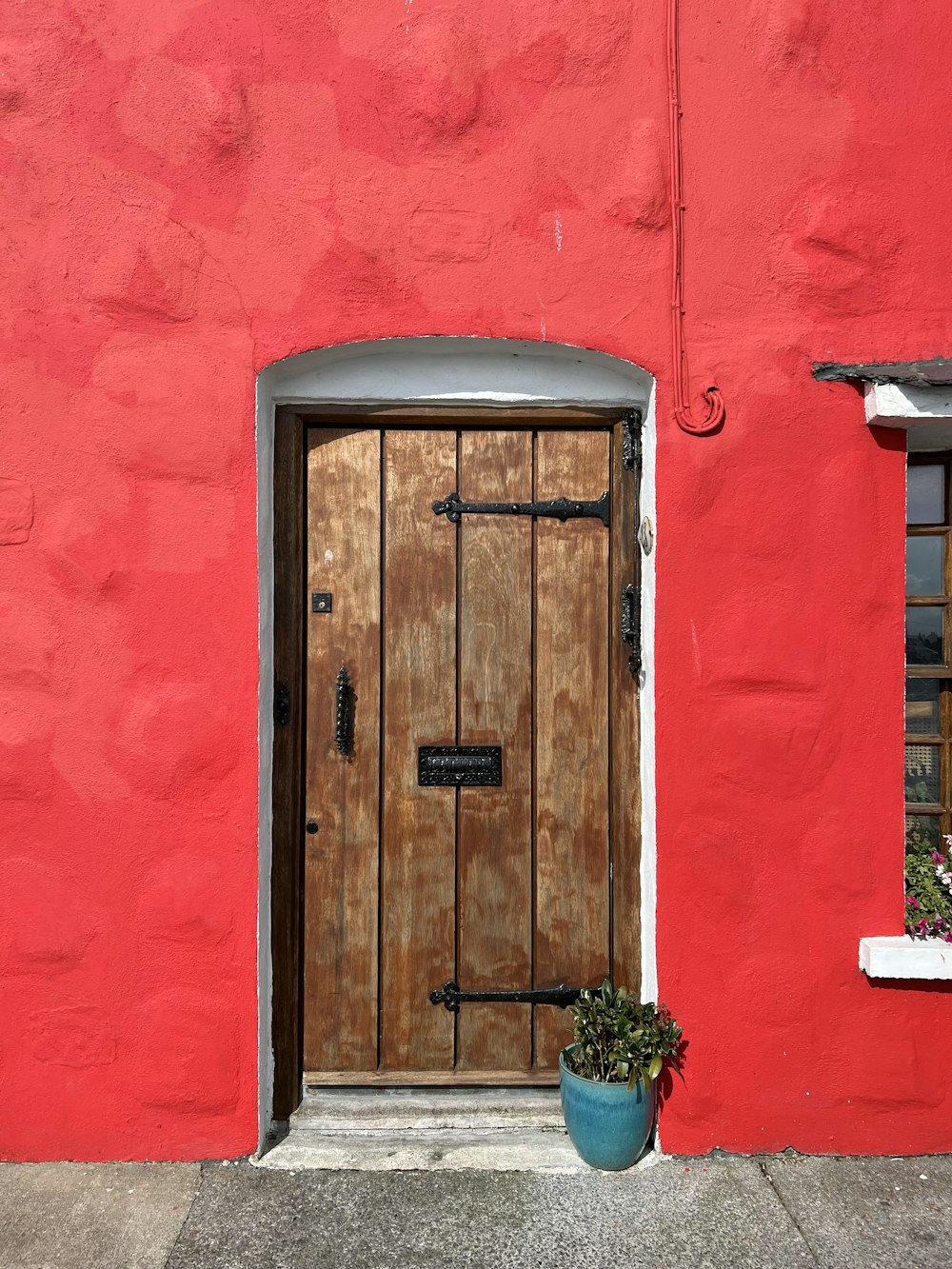 a red building with a potted plant in front of it