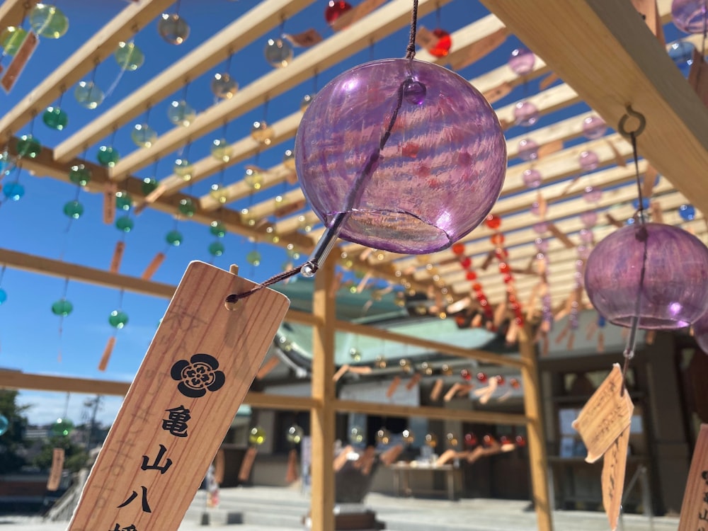a close up of a wind chime hanging from a wooden structure