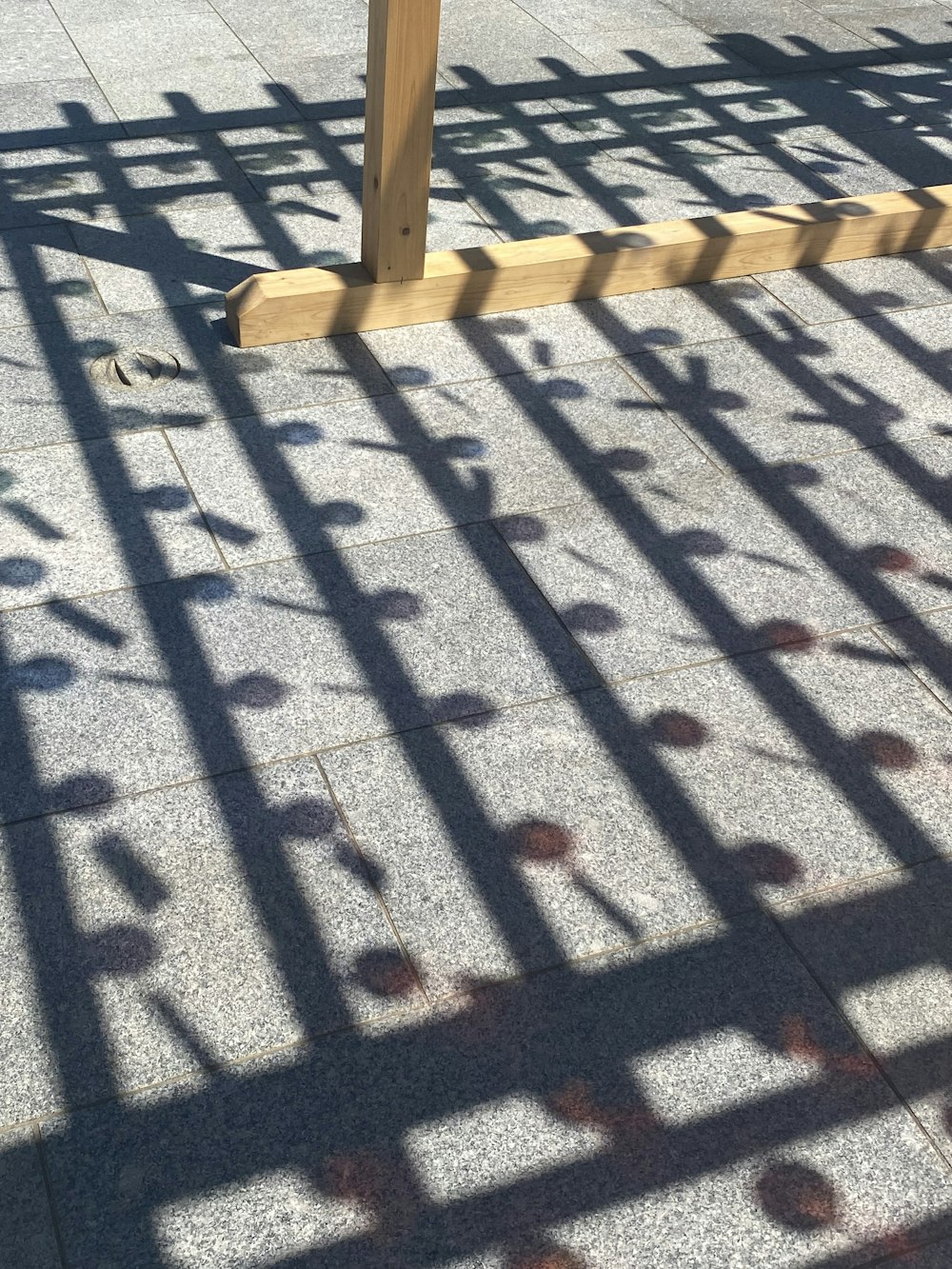 the shadow of a fence on the ground