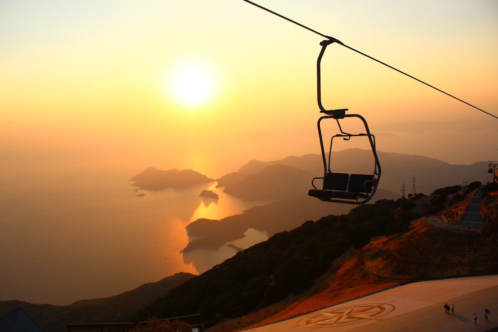 a ski lift going up a mountain at sunset