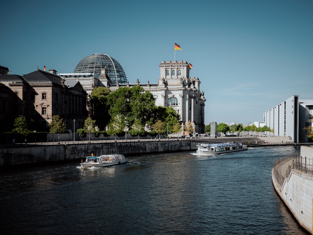 a boat traveling down a river next to a tall building