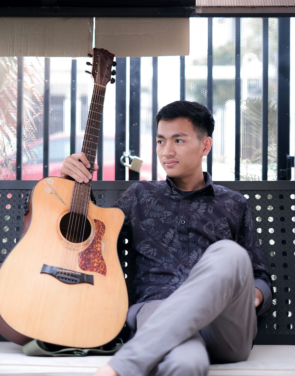 a man sitting on a bench holding a guitar