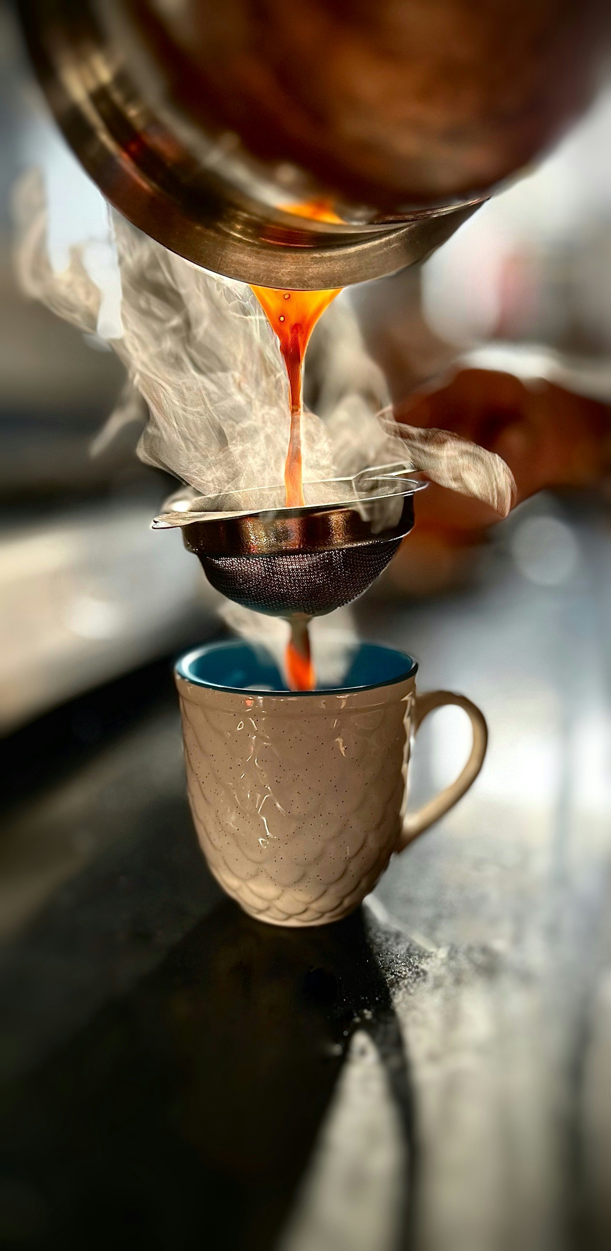 una persona che versa il liquido in una tazza su un tavolo