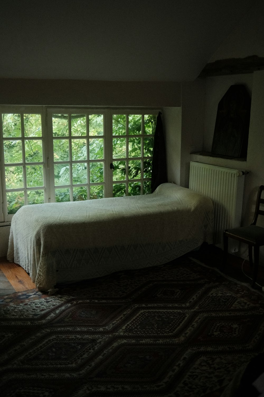 a bed sitting in a bedroom next to a window